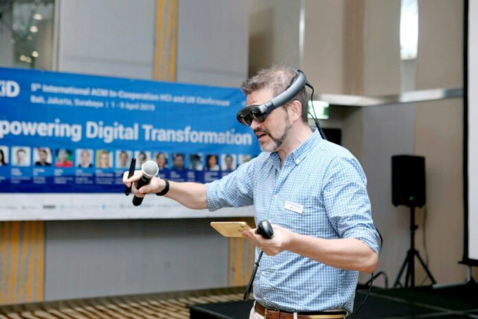 Mann mit Smartglasses präsentiert Technologie im Rahmen der Digital Transformation